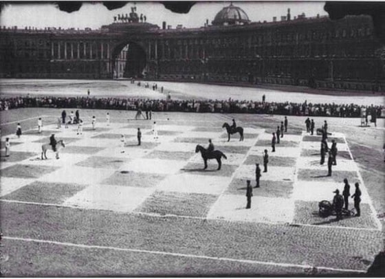 Katta shaxmat doskasidagi jonli figuralar.&nbsp; 1924-yil Leningradda Pyotr Romanovskiy va Ilya Rabinovich o'rtasida bo'lib o'tgan shaxmat o'yini.