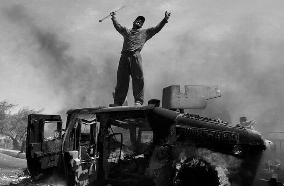 Iroq, Bog'dod shimolida AQSh armiyasining Hummer zirhli mashinasi va iroqlik erkak. 2004-yil