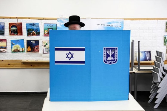 Isroillik yahudiy umumiy saylov kuni Quddusdagi saylov uchastkasida o'z byulletenini tanlamoqda.&nbsp; Foto: REUTERS/Ronen Zvulun