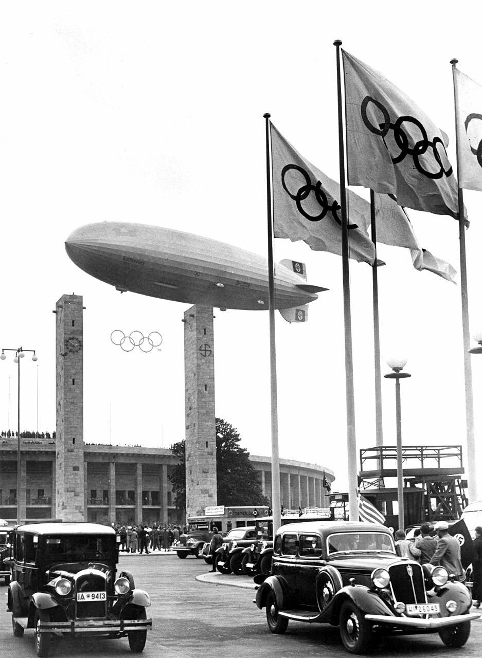 Olimpiya o'yinlarining ochilish marosimida ishtirok etgan Hindenburg havo kemasi. Berlin, 1936-yil<br>