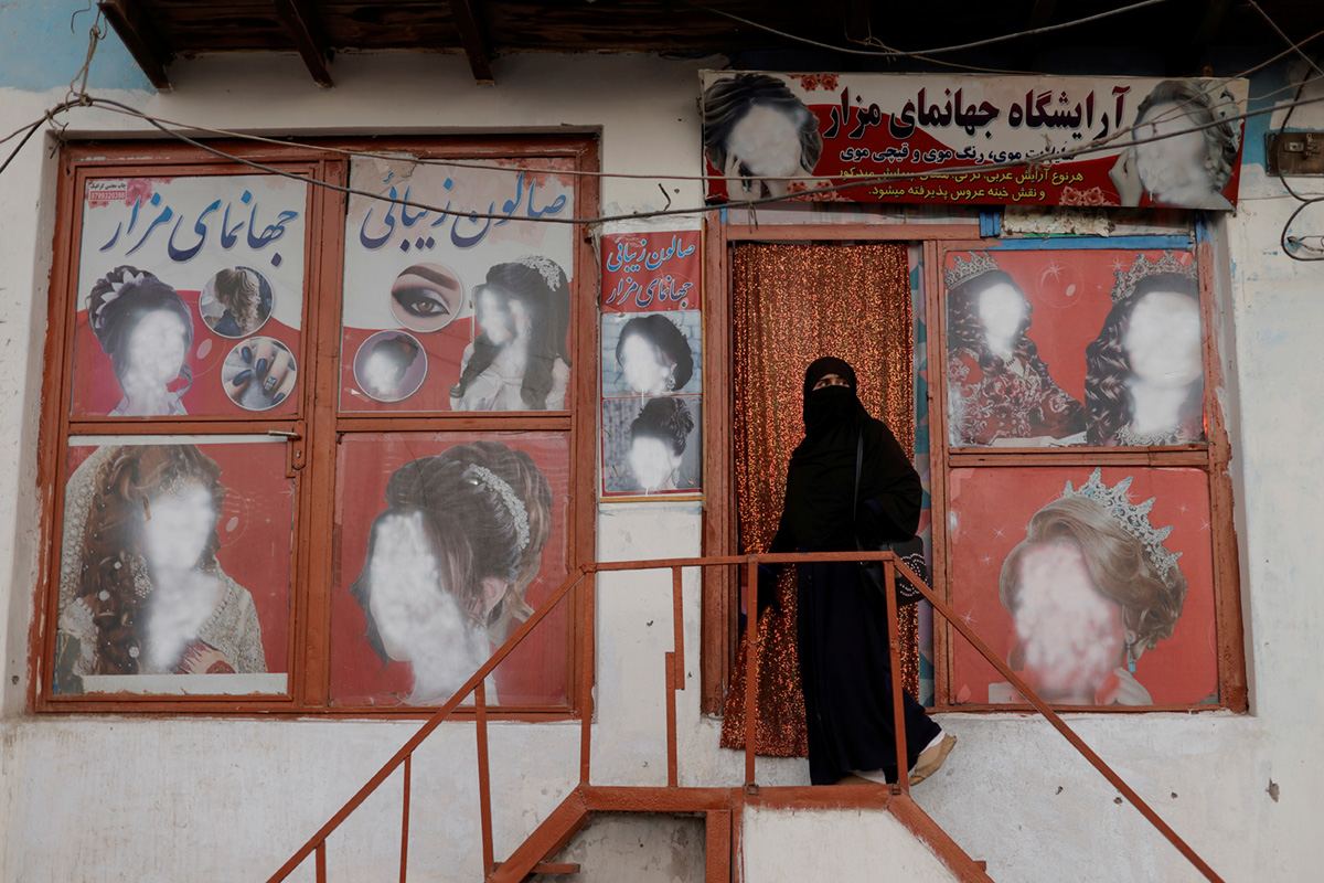 Витрины женского салона красоты с испорченной рекламой. Хозяйка салона закрасила изображение женских лиц на рекламных щитах из-за опасения погрома со стороны приверженцев движения Талибан, Кабул, Афганистан, 6 октября 2021 года. REUTERS / Jorge Silva