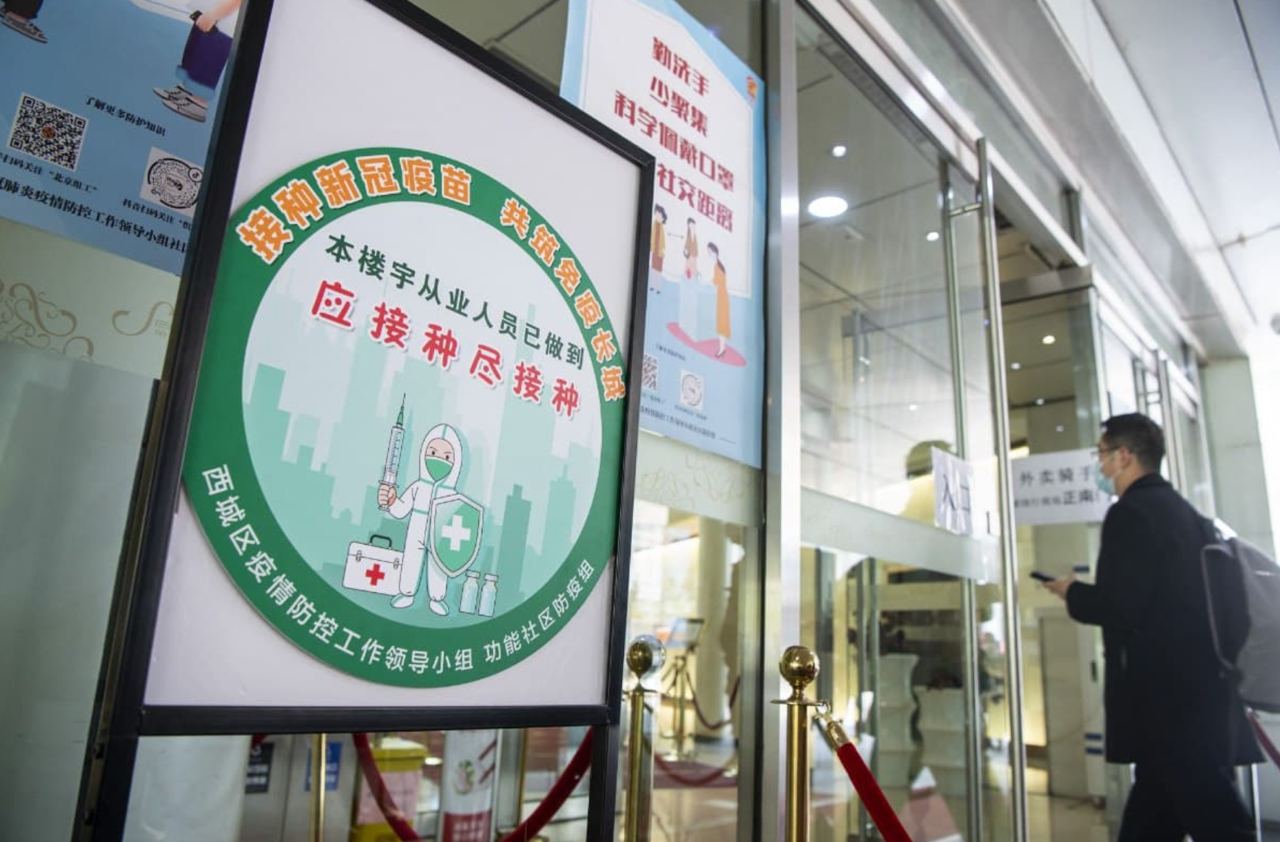 В Пекине на здания компаний вывешивают цветные знаки, показывающие количество вакцинированных сотрудников