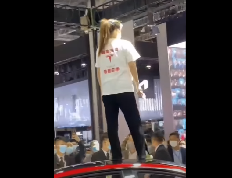 В Китае девушка залезла на автомобиль Tesla и протестовала против компании