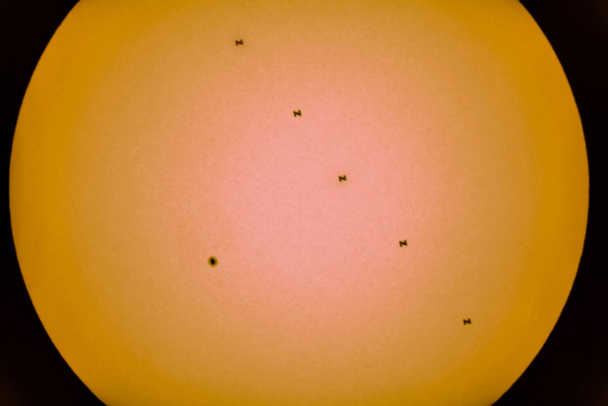 Изображение солнечного пятна и Международной космической станции на фоне Солнца, Снимок составлен из пяти отдельных фотографий и был снят вблизи Тбилиси, Грузия, 19 июня 2021 года. REUTERS/Irakli Gedenidze