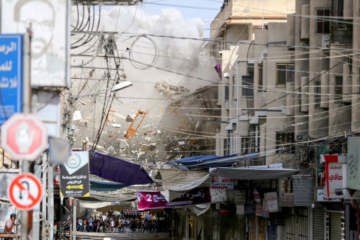 Обломки дома разлетаются, после израильского авиаудара в ходе израильско-палестинских боев в Хан-Юнисе на юге сектора Газа, 20 мая 2021 года. REUTERS / Ibraheem Abu Mustafa