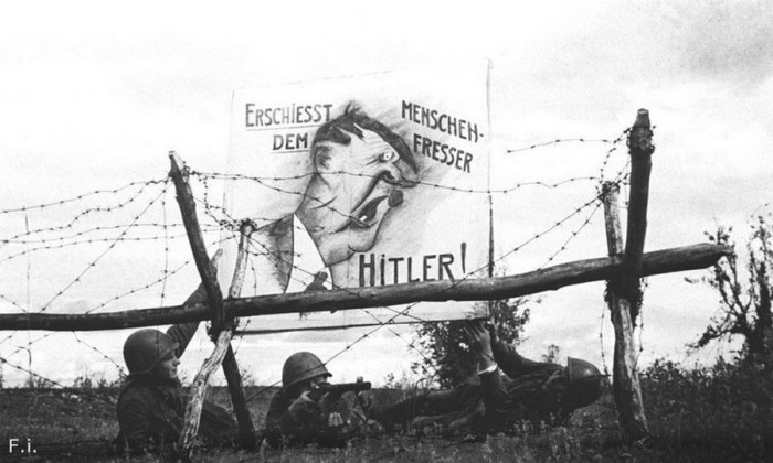 Бойцы рабоче-крестьянской Красной армии вывешивают карикатуру на Гитлера на передовой. Северо-Западный фронт, 1942 год.<br>