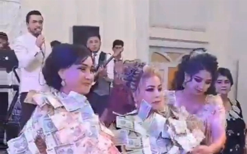 На одной из узбекских свадеб на родителей молодоженов надели чапан из денег — видео